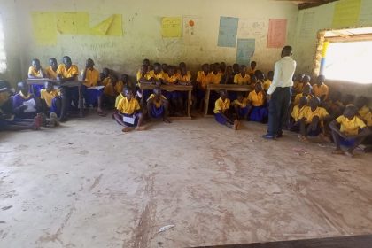 Schüler sitzen in Kenia auf dem Boden im klassenzimmer, da sie keine Schulmöbel haben - Social Team Event für Kenia
